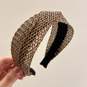 Close-up of woven straw headband with cross pattern and breathable mesh texture