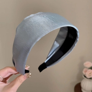 Detail of blue satin headband showing smooth silky texture and black non-slip lining