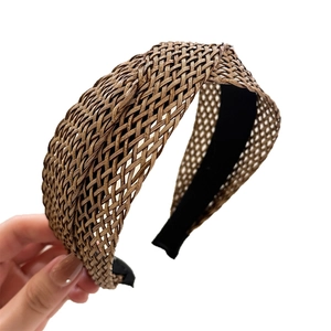 Elegant woven straw criss-cross headband in golden coffee brown with breathable mesh design