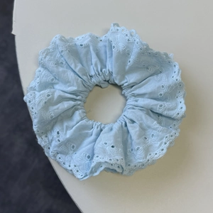 Elegant light blue lace scrunchie with intricate eyelet embroidery for high-end ponytails