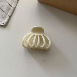 Detail view of cream vintage shell claw clip with elegant marble texture and cutout design