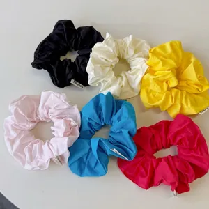 Colorful cotton hair scrunchies set in six vibrant colors with minimalist brand labels