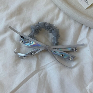 Detail of dark gray mesh scrunchie with satin bow and sparkling rhinestone accents