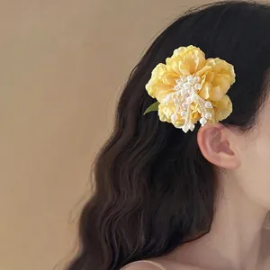 Fairy style yellow floral hair clip with white pearl tassels worn by a model