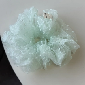 Détail du chouchou en organza vert menthe à pois avec étiquette tissée Hand Made