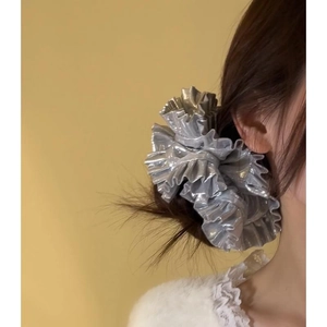 Detail showing oversized metallic silver pleated scrunchie with shiny ruffled texture