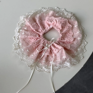 Detailed macro view of pink lace scrunchie with white embroidery and pearl bow