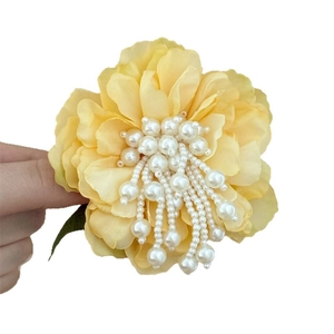 Floral hair clip with yellow fabric petals and long hanging white pearl tassels