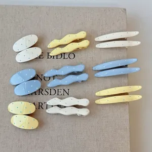 Geometric hair clips set with blue polka dots in oval and wavy shapes for women