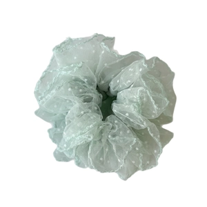 Mint green mesh polka dot hair scrunchie with lace trim edges on white background
