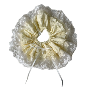 Sweet cream scrunchie with delicate lace edges and a faux pearl bow pendant accessory