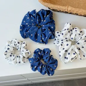 Set aus blau-weißen Blumen-Haargummis für Pferdeschwänze mit vintage Stoffstruktur