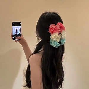 Pinza per capelli a fiore con petali di seta rosa bianchi e blu indossata da modella