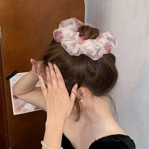 Chouchou romantique en organza à fleurs rose clair porté par un modèle pour un style doux