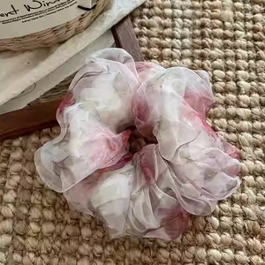 Gros plan détaillé du chouchou en organza floral avec imprimés roses sur fond de lin rustique