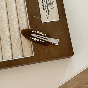Detail of French vintage acetate hair clip featuring amber texture and inlaid rhinestones