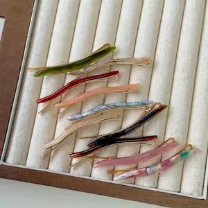 Elegant slim acetate leaf hair clips in various marble and solid colors on a display tray