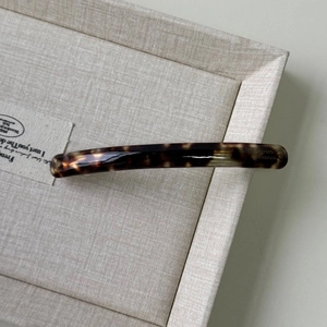 Macro detail of tortoiseshell acetate barrette hair clip with France lettering logo