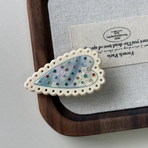 French style heart hair clip with colorful crystals on a warm wooden tray background