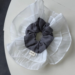 Detail of layered white chiffon and grey striped fabric scrunchie with Handmade label