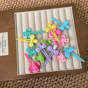 Set of pastel butterfly hair clips in macaron colors displayed on a wooden stand