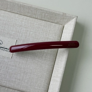 Macro shot of glossy dark red acetate hair clip with golden Barrette La France lettering