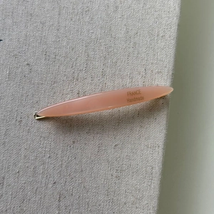 Close-up of peach acetate hair clip with gold-tone base and France Handmade text