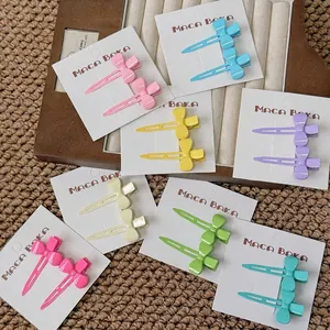 Set of pastel bow hair clips in multiple colors like pink, blue and yellow on display cards