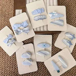 Sweet light blue fabric bow hair clips and flower hairpins for girls on a card
