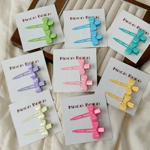 Set of 2 pastel macaron bow hair clips in 8 colors displayed on soft fabric