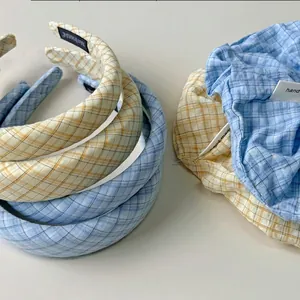 Blaues und gelbes Karo-Haarband-Set mit handgemachten Etiketten auf weißem Grund