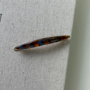 Detailed close-up of amber tortoiseshell hair clip with France Handmade gold lettering