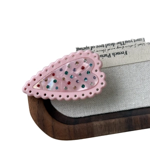 Pink heart-shaped hair clip with colorful rhinestones and mother-of-pearl texture