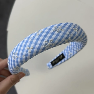 Close-up of blue and white plaid padded headband with white flower embroidery detail