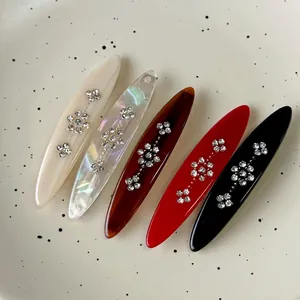 Set of 5 retro acetate hair clips with rhinestone flowers in various colors on ceramic plate