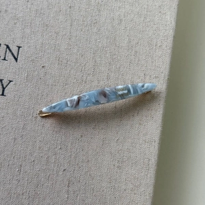 Close-up of blue marbled acetate spindle hair clip with France Handmade engraving