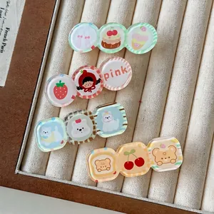 Lot de quatre barrettes à cheveux en acrylique avec ours et fruits sur plateau beige