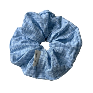 Handgefertigtes blaues Scrunchie-Haargummi mit Karomuster und feiner Stoffstruktur