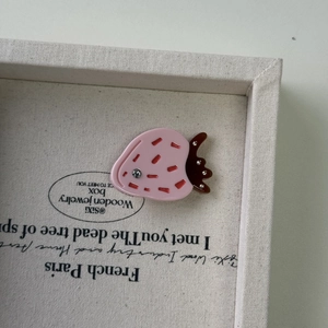 Dettaglio del fermaglio per capelli a fragola con texture rosa, venature rosse e strass