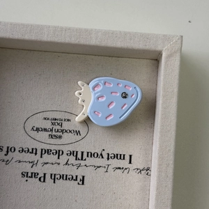 Dettaglio del fermaglio per capelli a fragola blu con accenti rosa e strass luccicanti