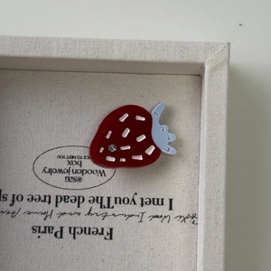 Dettaglio del fermaglio per capelli a fragola in acetato rosso con strass luminosi