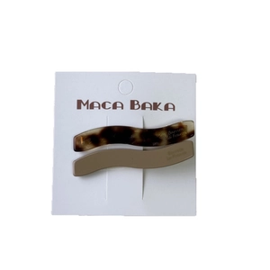 Set of two wavy acetate hair clips in tortoiseshell and taupe on a display card
