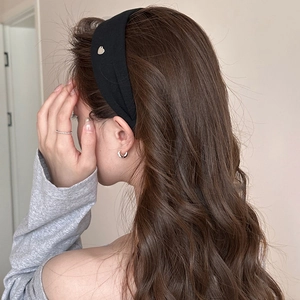 Detail view of the black fabric headband showing the silver heart metal accent on the side