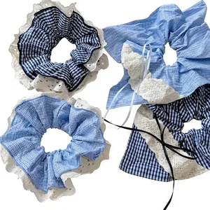 Set of four blue gingham hair scrunchies with white lace trim and ribbon details
