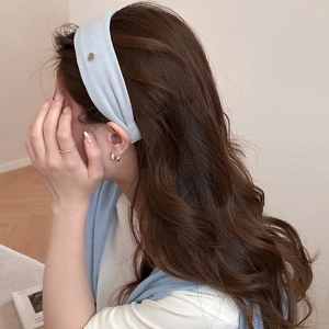Close-up of light blue knitted headband with metallic heart detail and soft texture