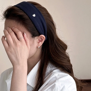 Detail of navy blue wide fabric headband with small silver heart metal accent on hair