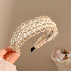 Detail of bohemian hand-woven linen headband featuring white lace hollow patterns