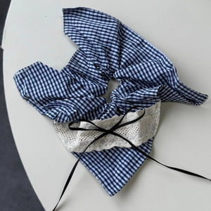 Detail of blue plaid hair tie featuring cream lace edges and a black satin ribbon bow