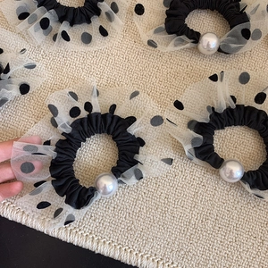 Detail of vintage French style black hair scrunchies with white polka dot lace and pearls