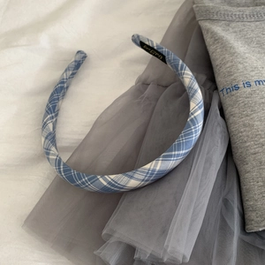 Detailed close-up of blue plaid fabric headband with elegant internal brand label